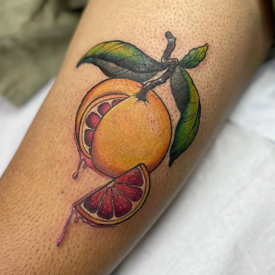 Color stylized upper thigh tattoo of a blood orange by tattoo artist Russ Howie.